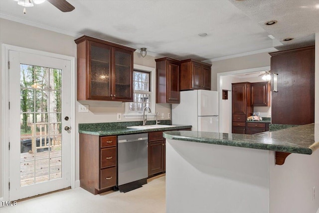 kitchen featuring stainless steel dishwasher, freestanding refrigerator, a peninsula, crown molding, and glass insert cabinets