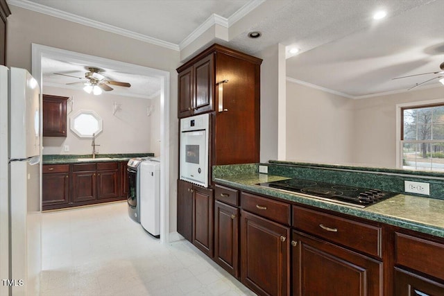 kitchen with ornamental molding, white appliances, light floors, washer / dryer, and ceiling fan