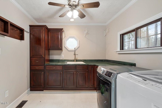 clothes washing area featuring light floors, cabinet space, a sink, a textured ceiling, and washer and clothes dryer