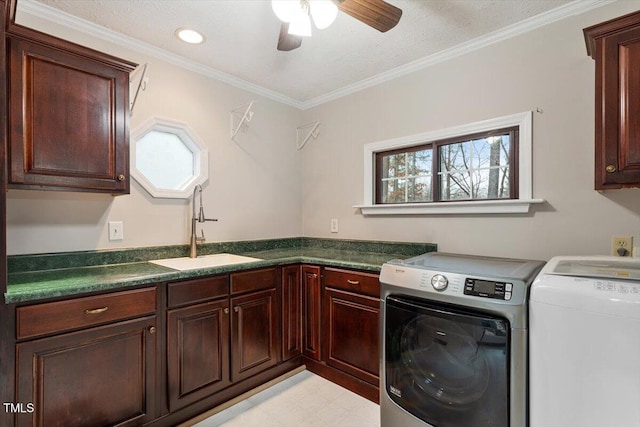 clothes washing area featuring washing machine and clothes dryer, cabinet space, a wealth of natural light, and a sink