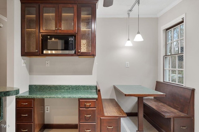 kitchen with stainless steel microwave, glass insert cabinets, and a wealth of natural light