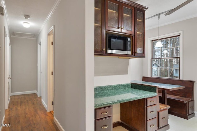 corridor featuring light wood-style floors, baseboards, and ornamental molding