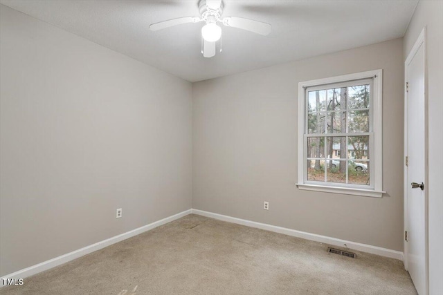 spare room with visible vents, baseboards, and light colored carpet