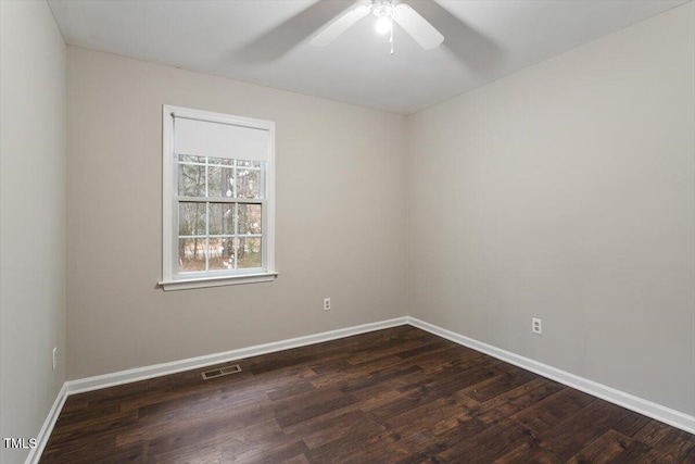 spare room featuring visible vents, baseboards, a ceiling fan, and dark wood-style flooring