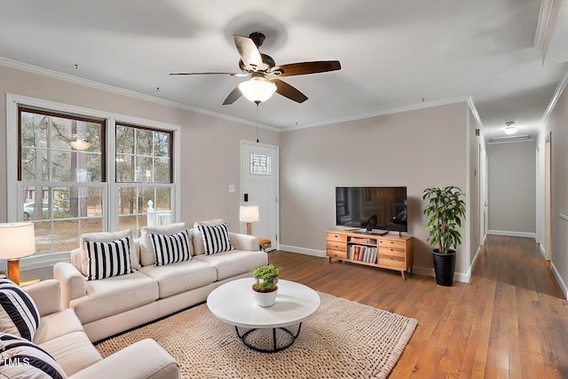 living room with hardwood / wood-style flooring, crown molding, and baseboards