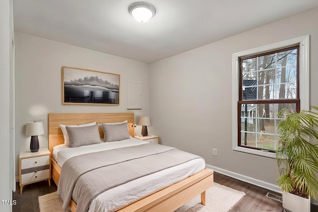 bedroom featuring visible vents, baseboards, and dark wood-type flooring