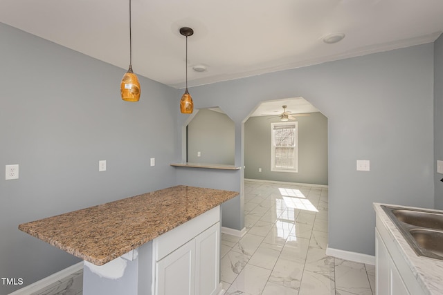 kitchen featuring white cabinetry, sink, pendant lighting, and ceiling fan