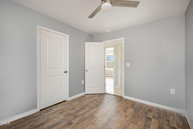 unfurnished bedroom featuring ceiling fan and dark hardwood / wood-style flooring