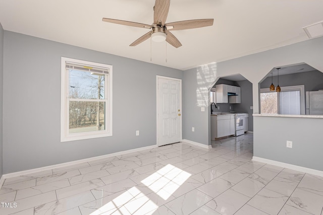 unfurnished living room with sink and ceiling fan