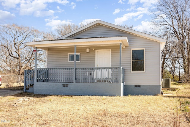 view of front of house featuring a front yard, central air condition unit, and covered porch