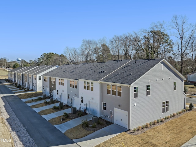 view of side of property with a garage and central AC unit