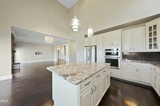 kitchen featuring appliances with stainless steel finishes, a kitchen island, pendant lighting, and white cabinets