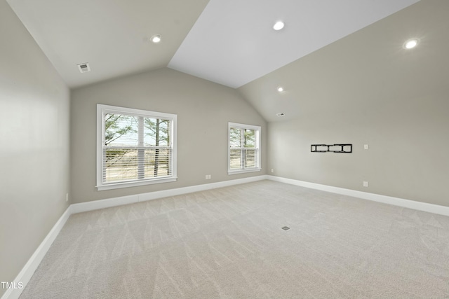 unfurnished room featuring light carpet and lofted ceiling