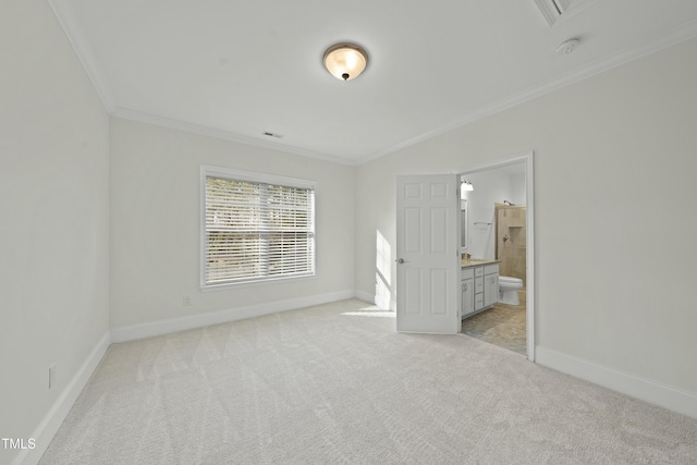 unfurnished bedroom with ornamental molding, ensuite bath, and light carpet