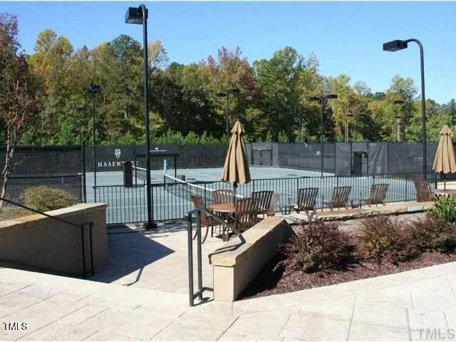 view of tennis court with a patio area