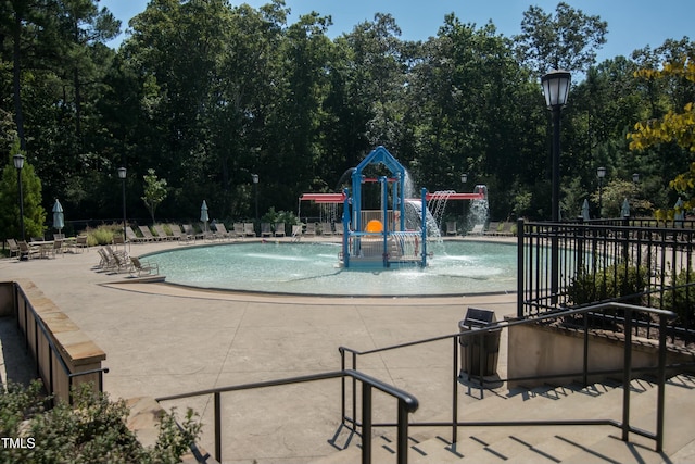 view of swimming pool featuring a playground