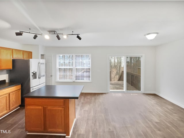 kitchen featuring a wealth of natural light, dark wood-type flooring, and a kitchen island