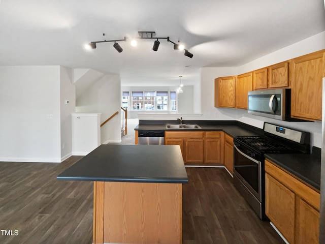 kitchen with pendant lighting, sink, appliances with stainless steel finishes, dark hardwood / wood-style floors, and kitchen peninsula