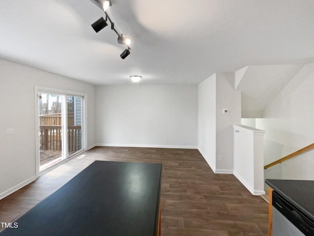 interior space with rail lighting and dark hardwood / wood-style flooring