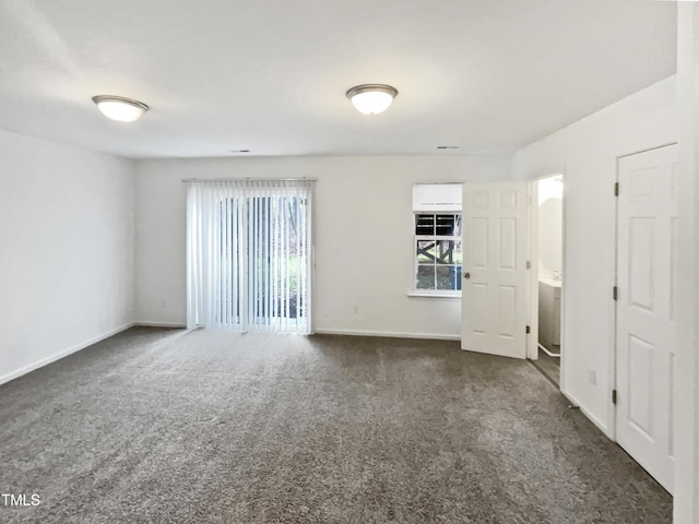 spare room with dark carpet