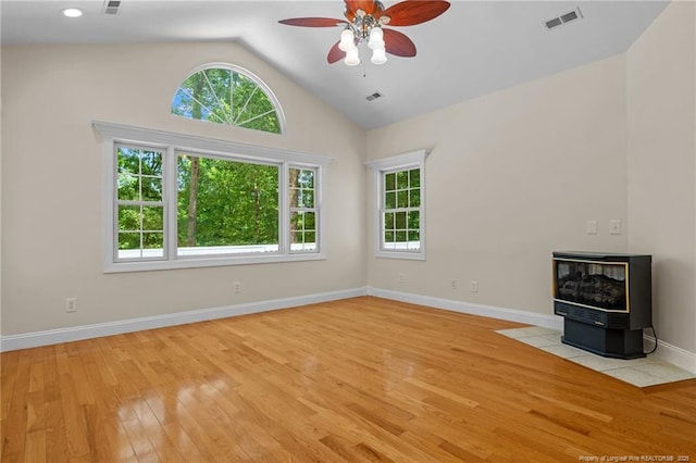 unfurnished living room with ceiling fan, vaulted ceiling, light hardwood / wood-style floors, and a healthy amount of sunlight