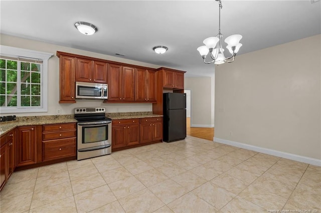 kitchen with light stone counters, pendant lighting, stainless steel appliances, and a notable chandelier