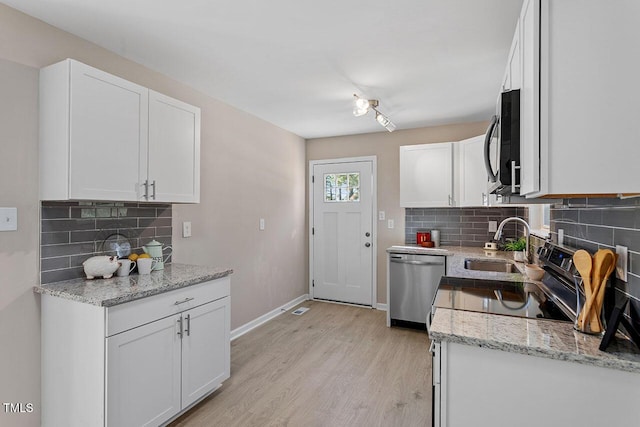 kitchen featuring sink, stainless steel dishwasher, white cabinets, and light hardwood / wood-style floors