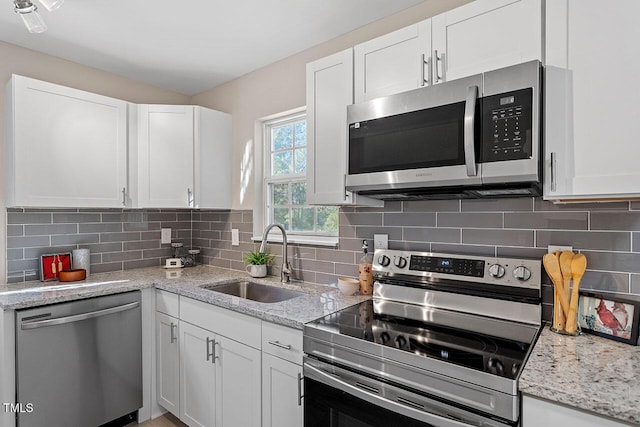 kitchen with white cabinetry, appliances with stainless steel finishes, sink, and decorative backsplash