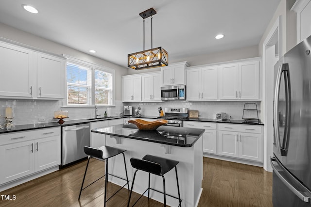 kitchen featuring white cabinetry, pendant lighting, stainless steel appliances, and a kitchen island