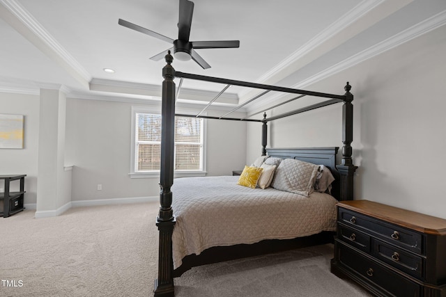 carpeted bedroom with crown molding, a tray ceiling, and ceiling fan