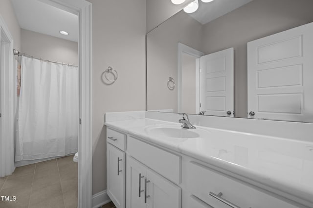 bathroom with tile patterned flooring, vanity, and toilet