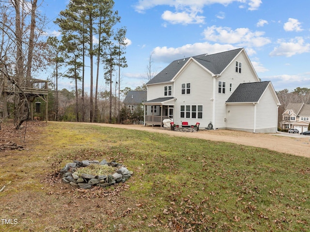 back of property featuring a lawn and covered porch