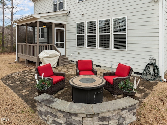 view of patio featuring a sunroom and an outdoor fire pit