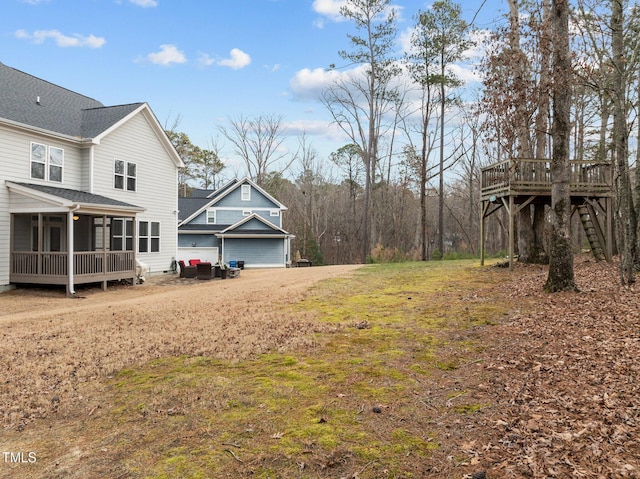 view of yard featuring a wooden deck and a sunroom