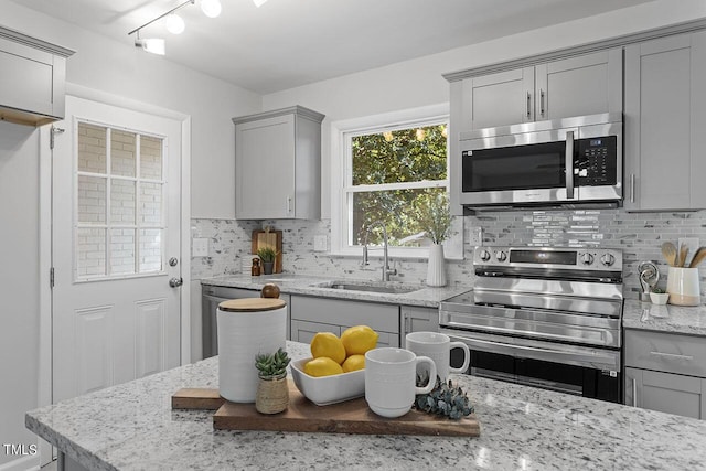 kitchen with gray cabinetry, sink, tasteful backsplash, and appliances with stainless steel finishes