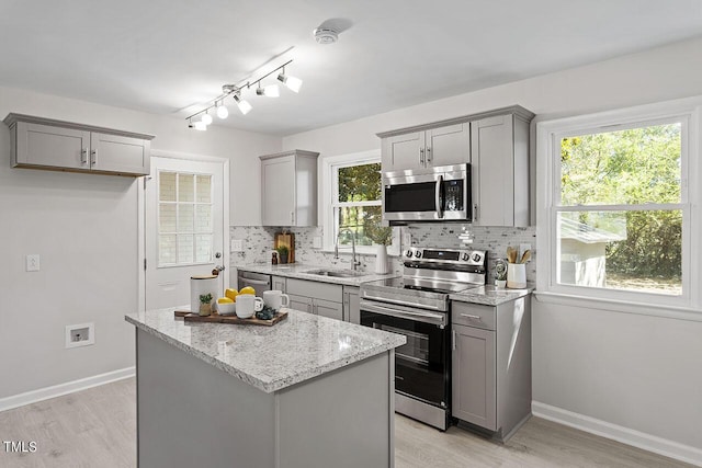 kitchen featuring tasteful backsplash, stainless steel appliances, sink, and a kitchen island