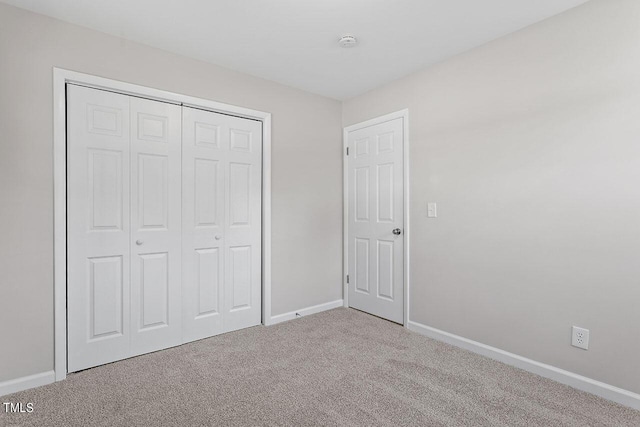 unfurnished bedroom featuring carpet flooring and a closet