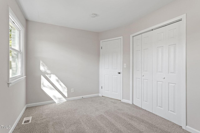 unfurnished bedroom with carpet flooring and a closet