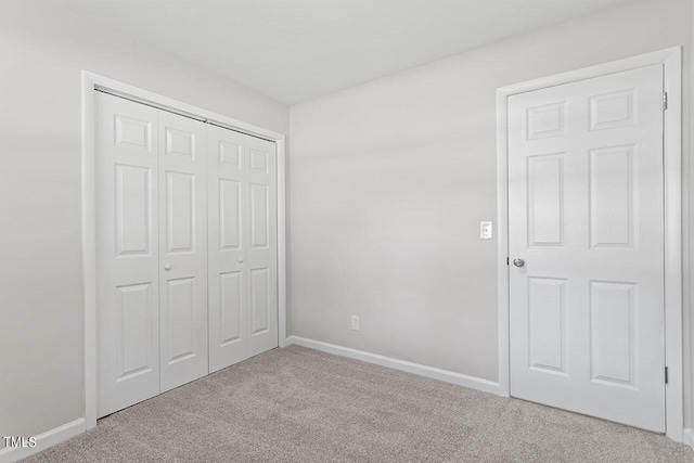 unfurnished bedroom with light carpet and a closet