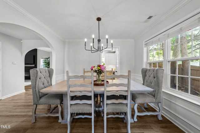 8005 Chatahoochie Ln, Raleigh, NC 27616 - dining space featuring arched walkways, a chandelier, ornamental molding, and wood finished floors