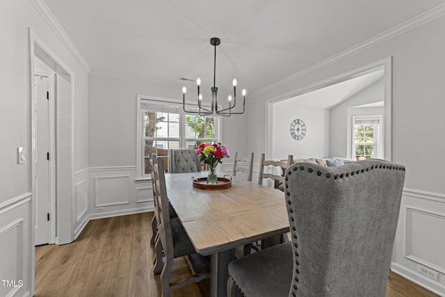 8005 Chatahoochie Ln, Raleigh, NC 27616 - dining room with a chandelier, wood finished floors, ornamental molding, a decorative wall, and wainscoting