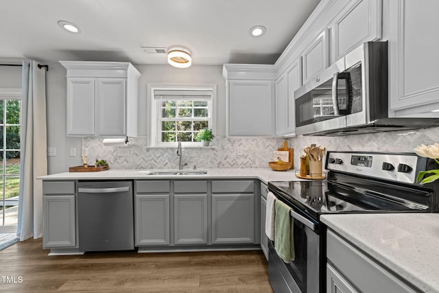 8005 Chatahoochie Ln, Raleigh, NC 27616 - kitchen featuring appliances with stainless steel finishes, gray cabinets, backsplash, light countertops, and recessed lighting