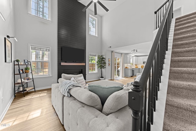 8005 Chatahoochie Ln, Raleigh, NC 27616 - living area with a high ceiling, stairs, plenty of natural light, light wood-type flooring, and a ceiling fan