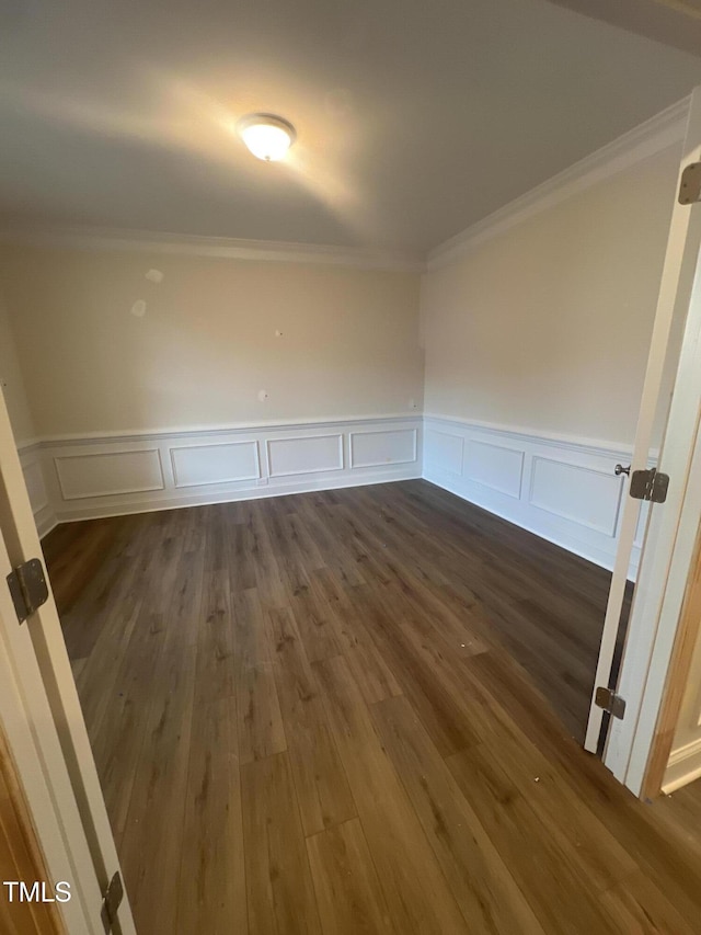 unfurnished room featuring ornamental molding and dark hardwood / wood-style flooring