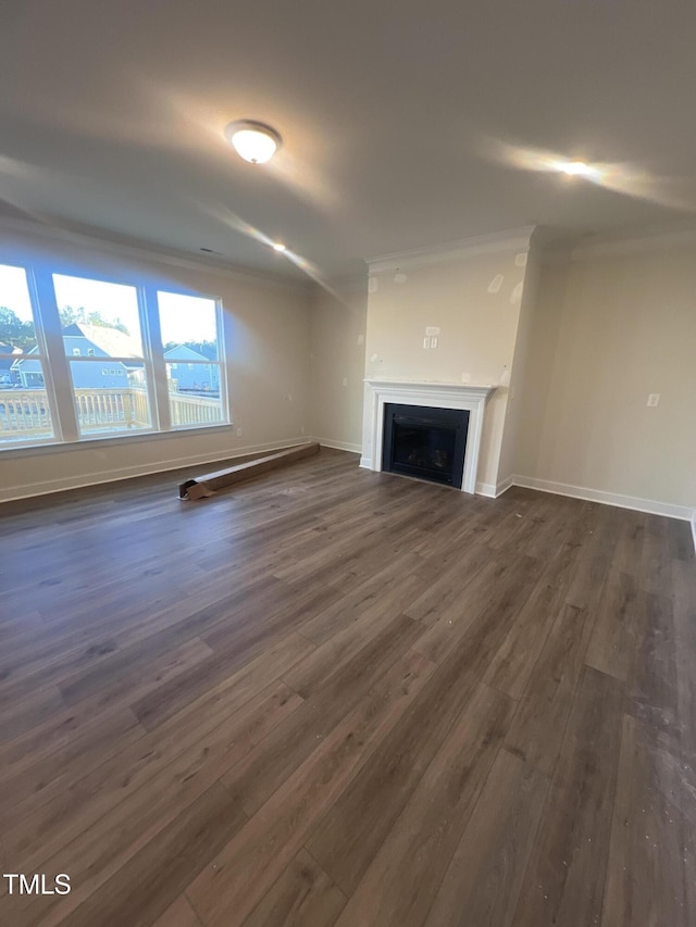 unfurnished living room featuring ornamental molding and dark hardwood / wood-style flooring