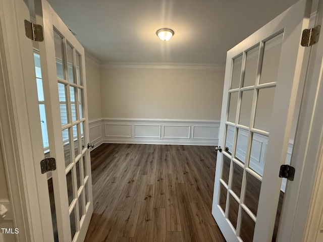 unfurnished dining area featuring ornamental molding, dark wood-type flooring, and french doors