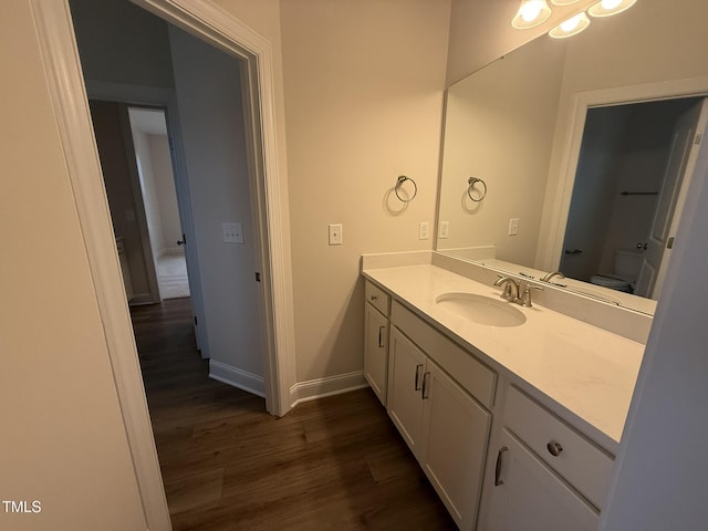 bathroom with vanity, hardwood / wood-style flooring, and toilet