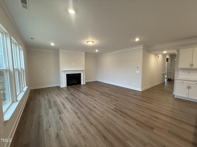 unfurnished living room featuring ornamental molding and wood-type flooring