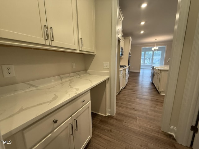 kitchen featuring pendant lighting, light stone countertops, and white cabinets