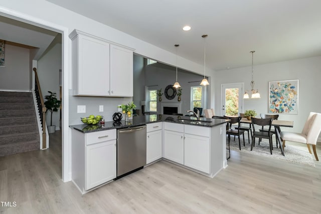 kitchen featuring sink, white cabinetry, decorative light fixtures, dishwasher, and kitchen peninsula